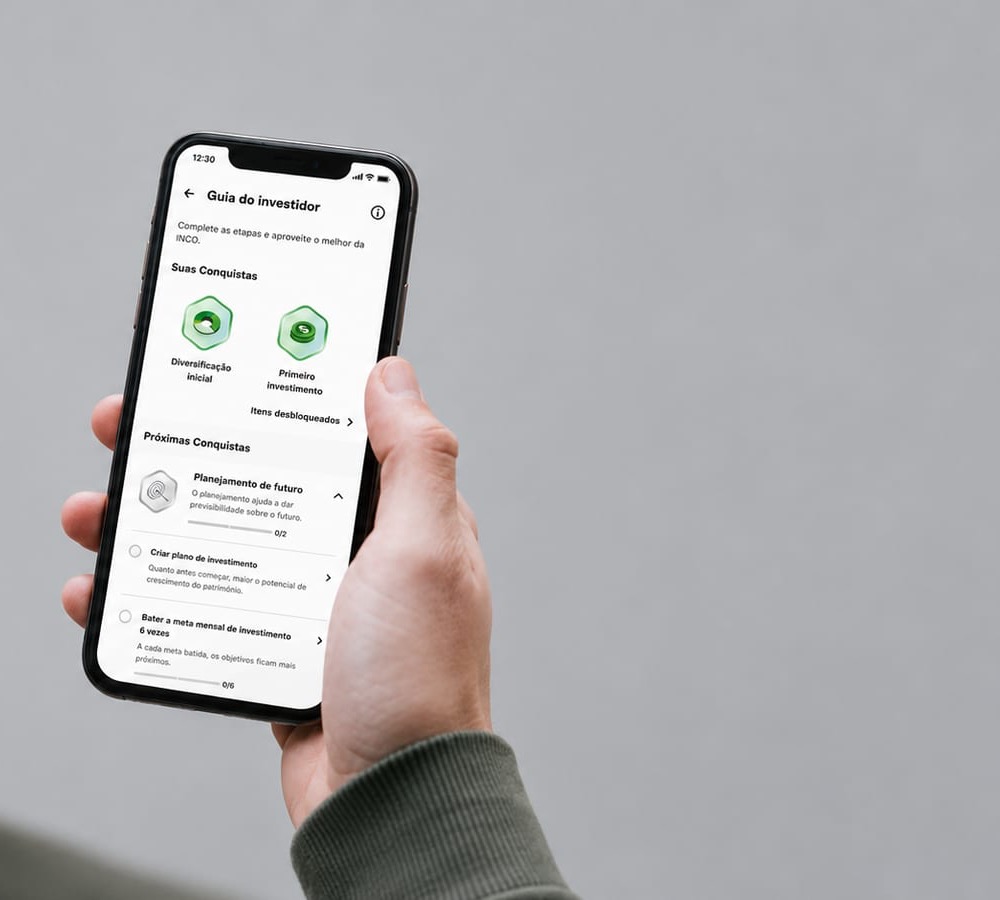O Guia do Investidor aberto no celular, na mão